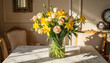 © Elen - A spring bouquet of yellow daffodils and pink roses in a glass vase on a marble table. Elegant home interior with classic furniture in warm sunlight