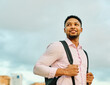 © Lumos sp - Portrait of a young man businessman or tourist  walking down the street, surrounded by modern corporate office buildings