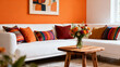 © Adobe Contributor - A white sofa adorned with colorful pillows, a vase of flowers, and an orange wall in a well-decorated living room.