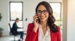 © vadosloginov - Smiling businesswoman in red blazer on phone call