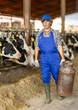 © JackF - Hardworking middle-aged male farmer carrying metal milk tank at dairy facility