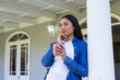© Wavebreak Media - Asian woman standing on porch leaning on white column holding clay mug touching chin