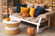 © Pixel-Shot - Autumn interior of cozy living room with sofa, coffee table and pumpkins