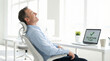 © Andrei Liashchou - Relaxed Man After Successful Online Tax Filing in Modern Office