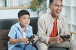© itchaznong - Father and son gaming together, sharing joyful moments at home