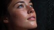 © Thares2020 - Close up portrait of a young woman s face with water droplets on her skin looking up serenely