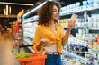 © Serhii - Woman shopping choosing yogurt in supermarket dairy aisle