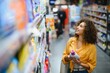 © Serhii - Woman choosing laundry detergent in supermarket aisle