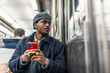 © unai - Young man commuting on subway looking out window