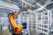 © BusinessClass by W61 - Engineer standing beside industrial robot arm in modern factory