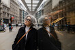 © TrueShot | Westend61 - Businesswoman in smart casual looking up with reflection in city street