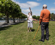 © TrueShot | Westend61 - Couple enjoying playful outdoor activity with hula hoop in sunny park