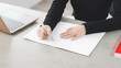 © metamorworks - Woman writing in a notebook at a desk