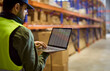 © Studio Romantic - Warehouse inventory worker uses laptop for stock. He checks goods on shelves and updates storage records to support logistics, audit and management. Clear concept of inventory management.
