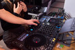 © Евгений Вершинин - DJ setup overview, Energetic club DJ performing with digital controller in action, Content creator mixing music live using digital turntables under vibrant stage lights