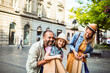 © Davor - Happy adult parents with child daughter shopping on a sunny city street