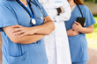 © StockMe - Close-up of the crossed arms of a united medical team, demonstrating confidence and professionalism in their healthcare work