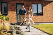 © Maria Vitkovska - Happy smiling family with child running out of new home on the street