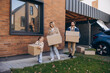 © Maria Vitkovska - Smiling happy family moving into new house carrying cardboard boxes