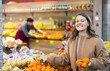 © JackF - Happy young girl chooses and buys ripe delicious tangerines in grocery section of the supermarket