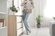 © Pixel-Shot - Young woman with newspapers near commode at home