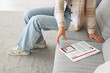 © Pixel-Shot - Young woman with newspaper sitting on sofa at home