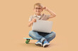 © Pixel-Shot - Little boy with laptop studying computer sciences on beige background