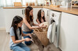 © Kawee - Asian beautiful mother teaching young daughters doing laundry at home.