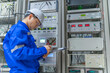 © reewungjunerr - Electrical engineer woman checking voltage at the Power Distribution Cabinet in the control room,preventive maintenance Yearly,Thailand Electrician working at company