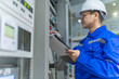 © reewungjunerr - Electrical engineer woman checking voltage at the Power Distribution Cabinet in the control room,preventive maintenance Yearly,Thailand Electrician working at company