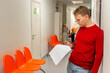 © KseniaJoyg - A young man is waiting in the corridor of a medical clinic in front of a doctor's office. a patient
