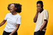© SHOTPRIME STUDIO - Joyful young African American couple laughing together against a bright yellow background wearing stylish glasses, conveying happiness and connection