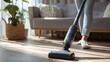 © Ирина Рычко - Person vacuuming bedroom carpet with modern cordless cleaner