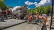 © HyperlapsePro - Concrete leveling works for road construction with many workers and mixer timelapse