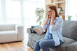 © Dragana Gordic - Woman Suffering From Headache At Home On Couch In Cozy Living Room Setting