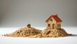 © bell - A photo that features a close up of two miniature houses in sand and rock isolated against a white background