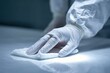 © YanabY - Cleaning a surface with a cloth while wearing gloves in a room during daylight hours