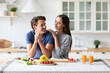 © BestForYou - Smiling man in a blue shirt is sitting at a kitchen table with a woman in a gray shirt.