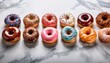 © Kevin - rows of various glazed doughnuts with different toppings creating a vibrant snack selection on white marble