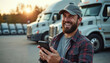 © Viktor - Bearded man in cap smiles holding smartphone. He stands near parked trucks, looking happy while using his mobile device. A delivery driver is on his phone.