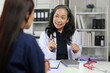 © Wasan - Experienced Asian female doctor explaining diagnosis to her patient during a medical consultation in clinic, providing healthcare and support.