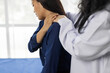 © Wasan - Female doctor examining shoulder and neck of young female patient suffering from stiff neck and shoulder pain in clinic room, healthcare and medical concept.