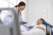© Wasan - Female doctor is checking on a senior patient who is recovering from surgery in a hospital room.