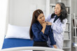 © Wasan - Doctor examining patient's shoulder and neck in hospital room.