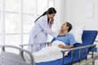 © Wasan - Female doctor examining a senior patient lying in hospital bed using a stethoscope.