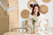 © Pixel-Shot - Pretty young woman serving table with beautiful flowers in dining room