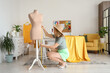 © Pixel-Shot - Female tailor measuring beige mannequin in atelier