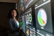 © artitwpd - A professional Indian businesswoman interacts with a large digital dashboard displaying charts and analytics in a modern office. Leadership, planning, and data-driven strategy in tech-driven business.