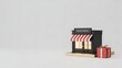 © ROBIULAWAL - Miniature shop with red and white striped awning and a gift box isolated on white background