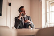 © Jelena - Businessman Engaged in a Phone Call in a Modern Office Setting